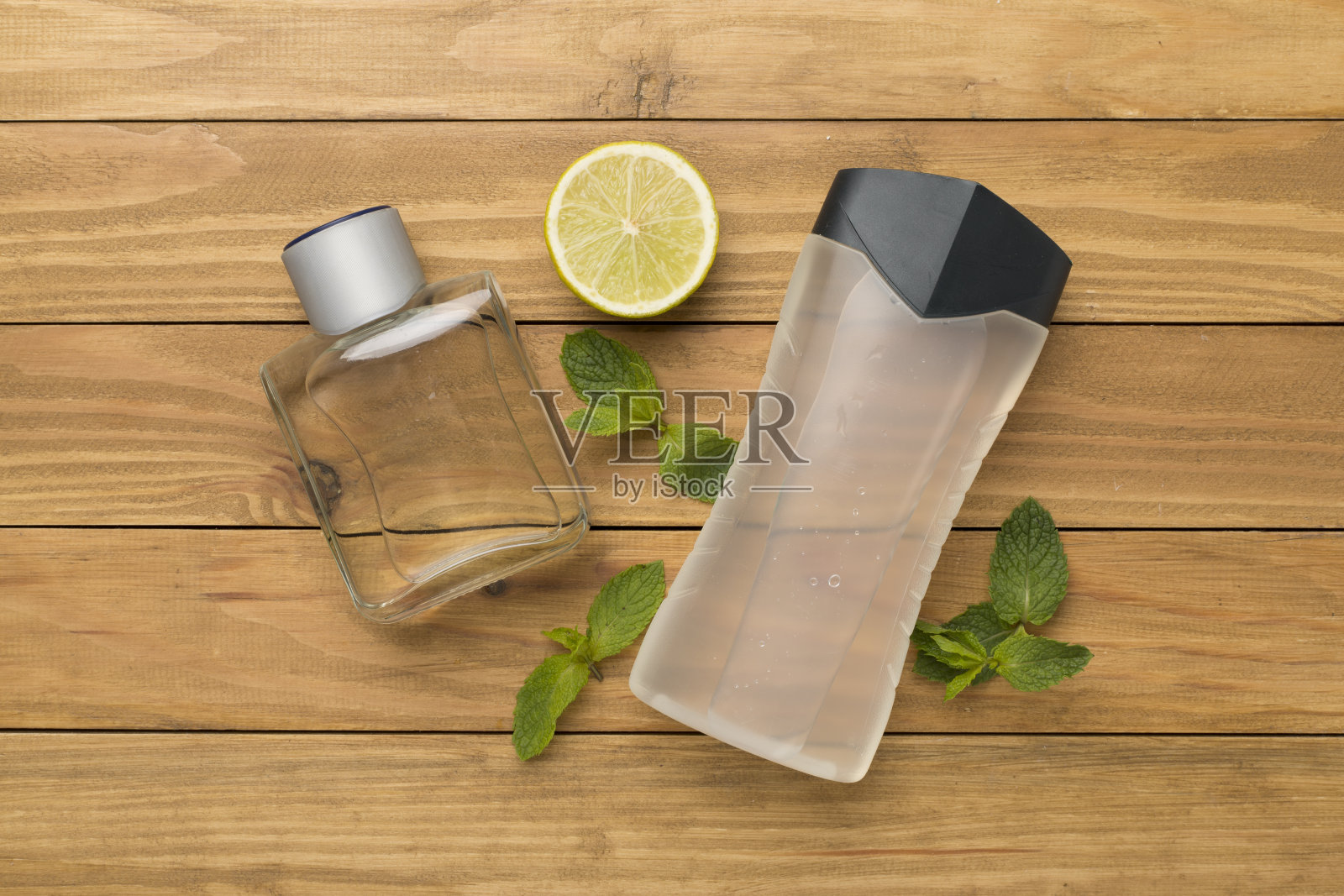 男性化妆品瓶与薄荷叶木制背景，俯视图照片摄影图片