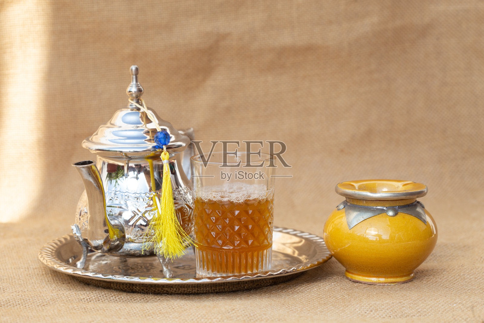 摩洛哥传统的茶壶和杯子放在银盘子上的特写照片摄影图片