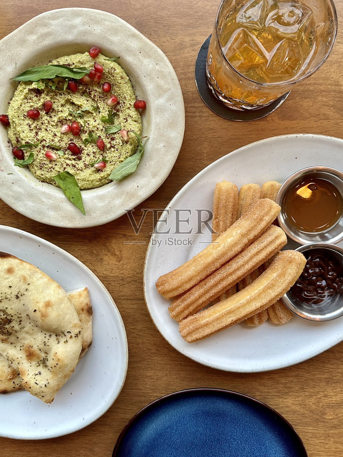 烤饼配上绿色鹰嘴豆泥，油条配上焦糖和巧克力蘸料照片摄影图片