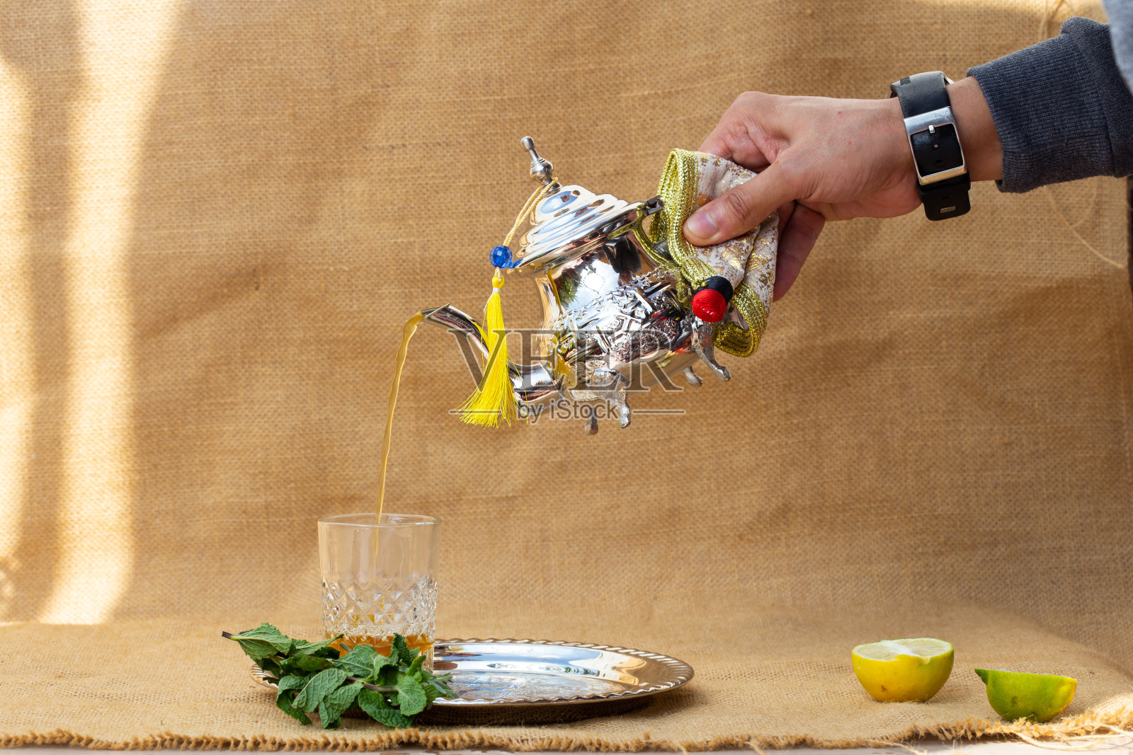 摩洛哥传统的茶壶和杯子放在银盘子上的特写照片摄影图片