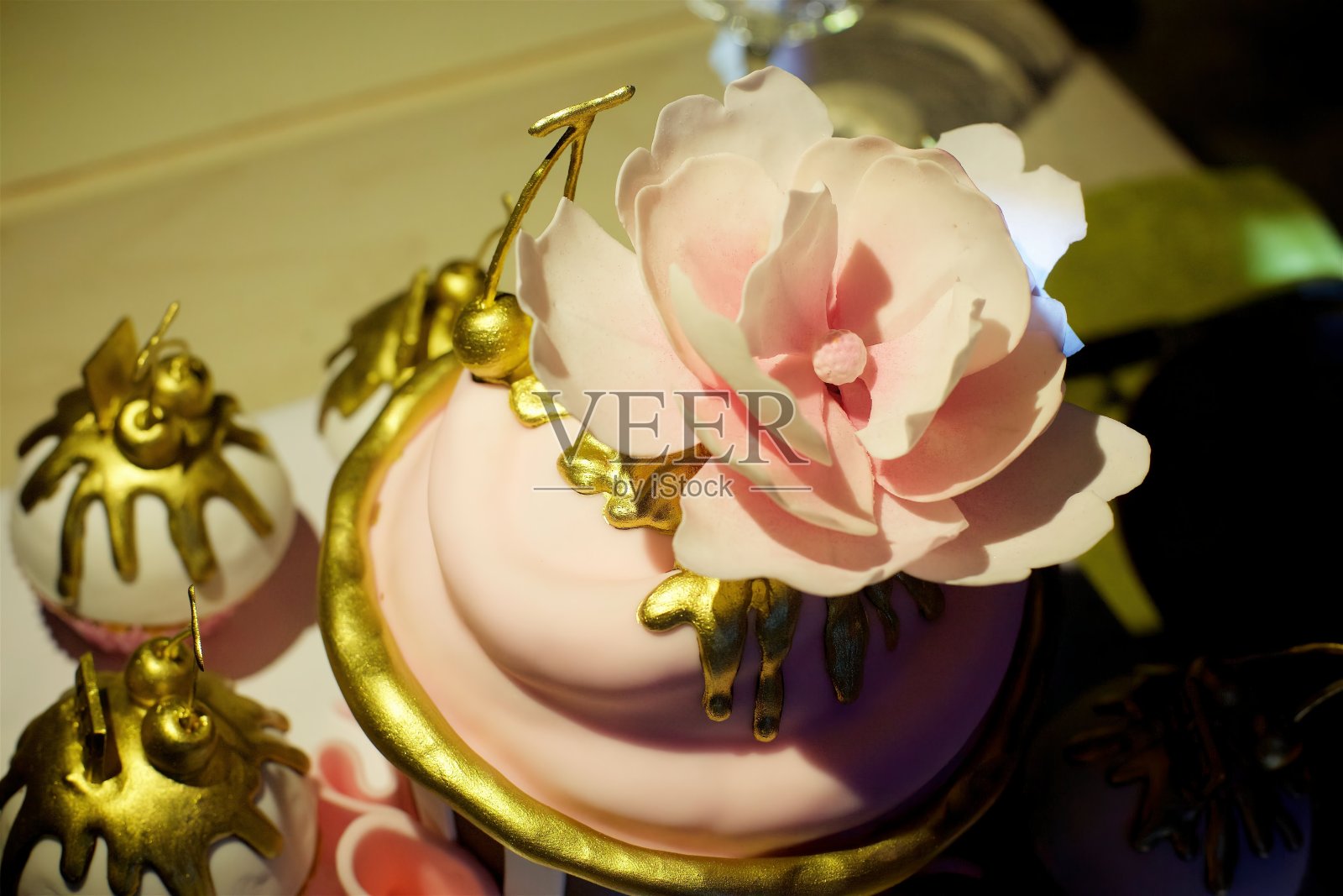 给一个金色和粉色的女孩的蛋糕。照片摄影图片