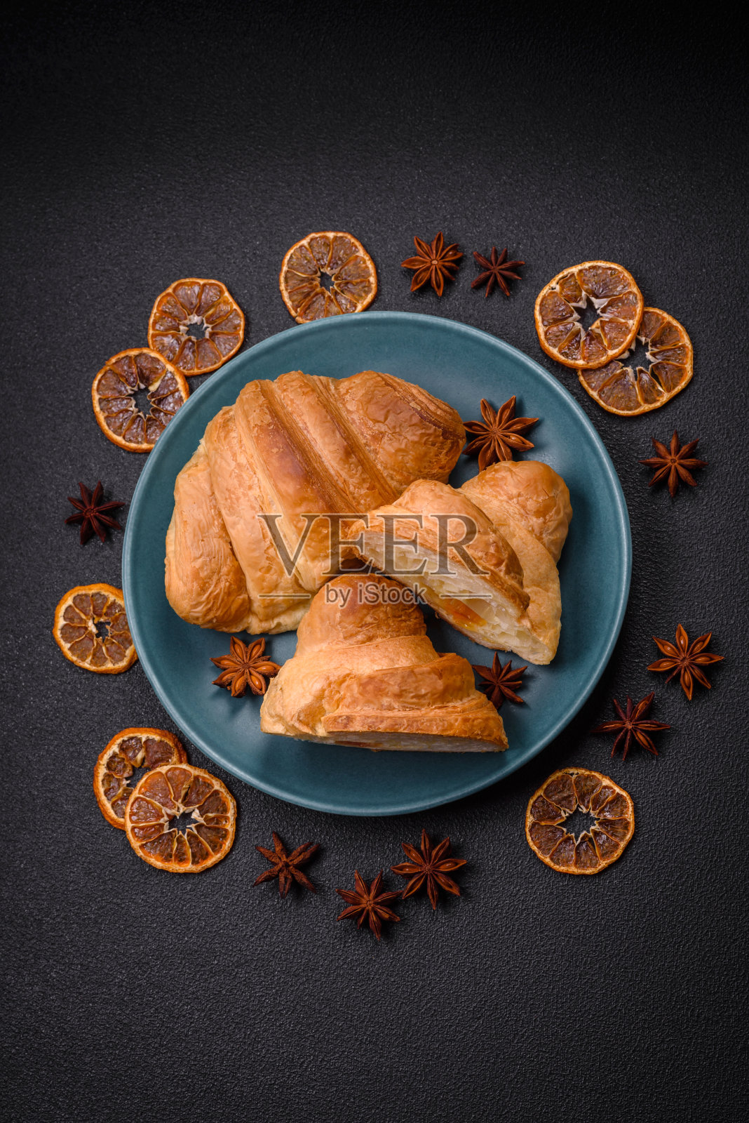 美味酥脆的烤甜羊角包，夹在陶瓷盘子里照片摄影图片