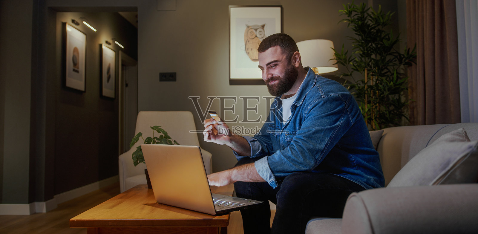 人、坐、电脑、电子产品、笔记本电脑、个人电脑、成人、男性、男人、脸、头、盒子、沙发、家具、纸板、纸箱、包装、包裹递送、建筑、建筑、室内、客厅、房间、阅读、社会、艺术、人类、文化、便携式电脑、室内、科技照片摄影图片