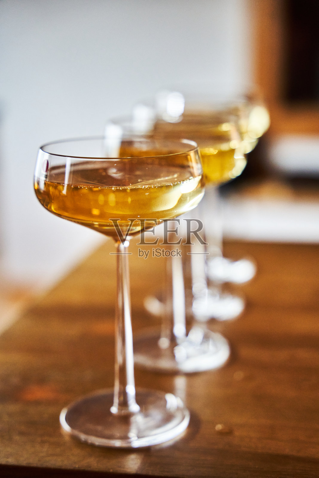 玻璃杯的特写，充满活力的黄色液体并排站立。照片摄影图片