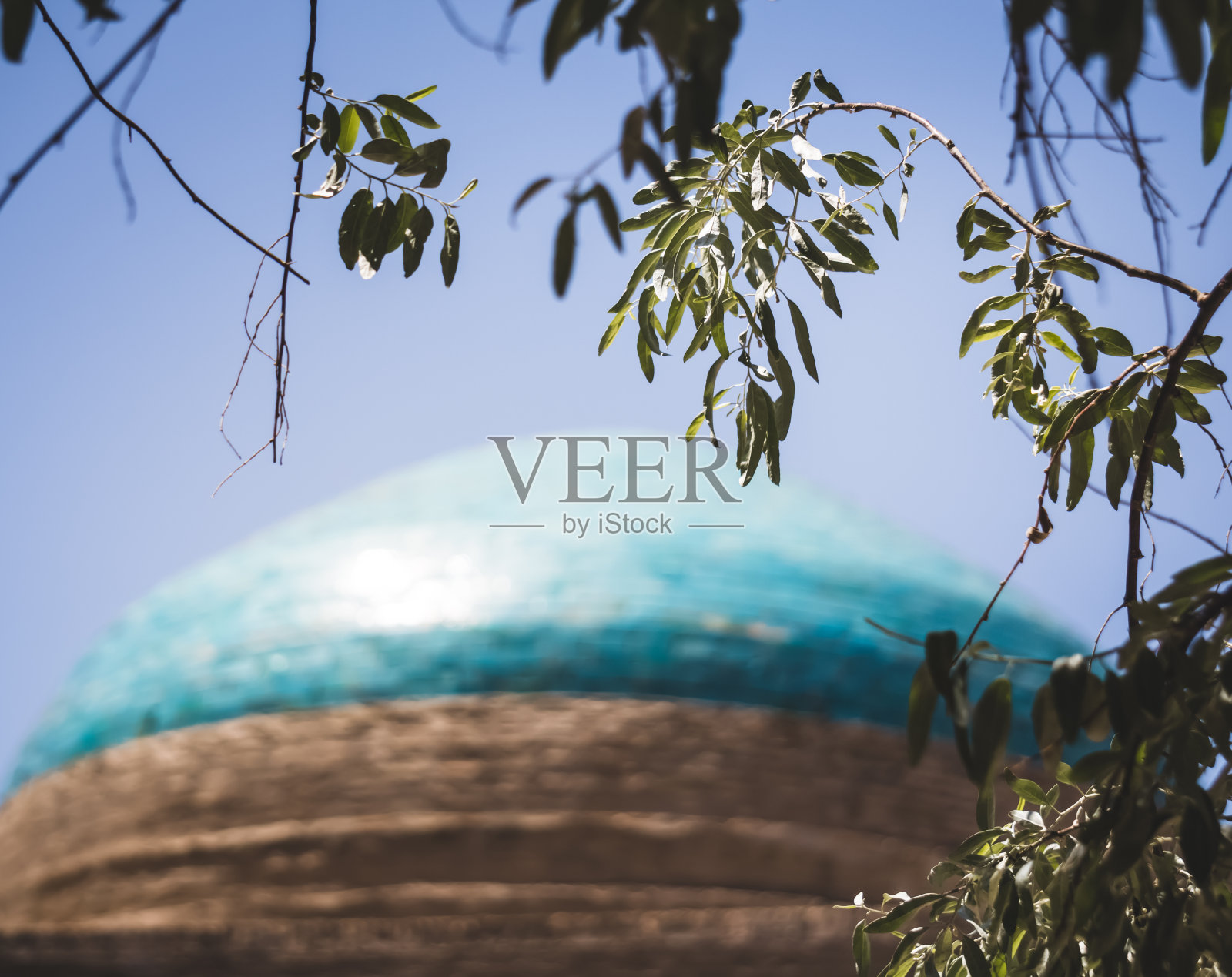 这座古老陵墓的圆顶上铺着蓝色瓷砖和釉面马赛克，位于花剌孜姆的希瓦古城照片摄影图片