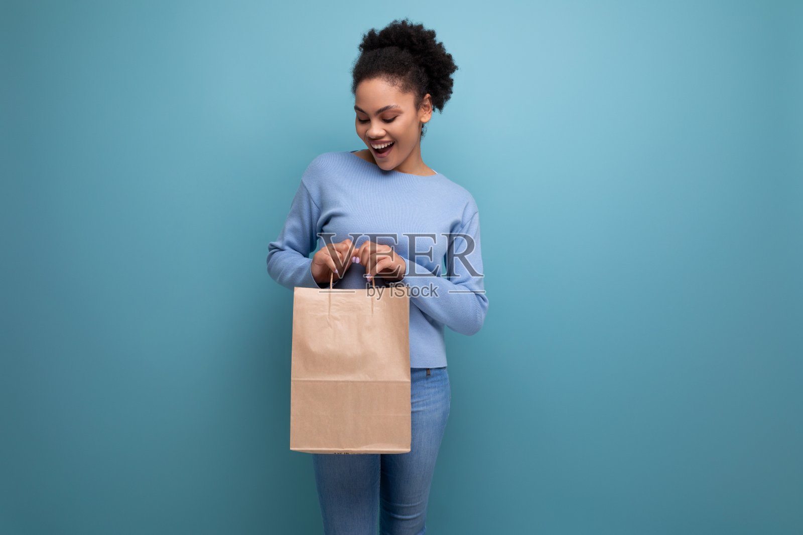 积极的黑发女人拿着可回收的工艺包照片摄影图片