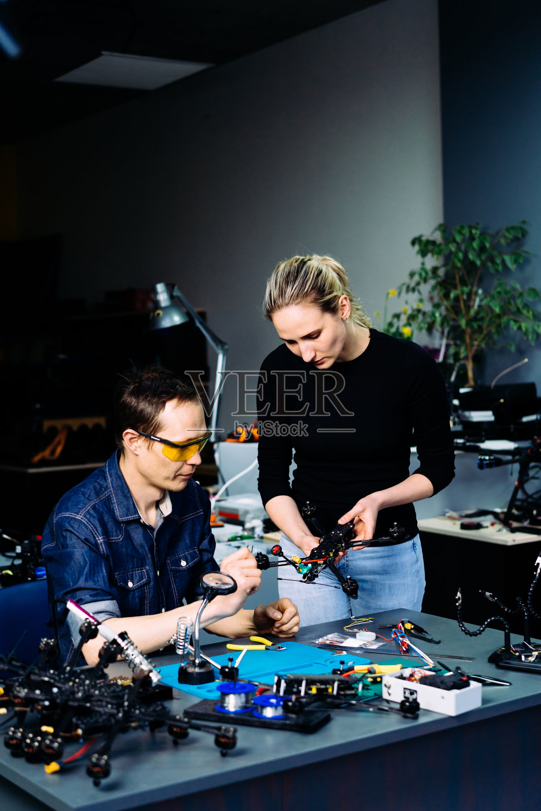 男工程师和女工程师在车间里研究赛车无人机照片摄影图片