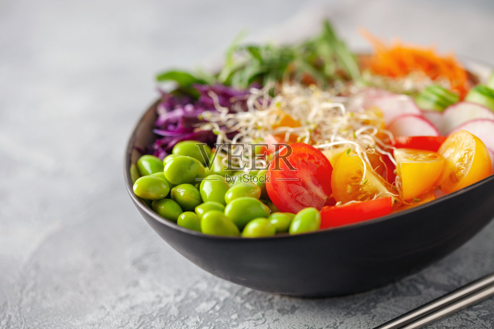 佛碗。黄瓜，胡萝卜，芝麻菜，红卷心菜，毛豆和芝麻。美味均衡健康食物的概念。照片摄影图片