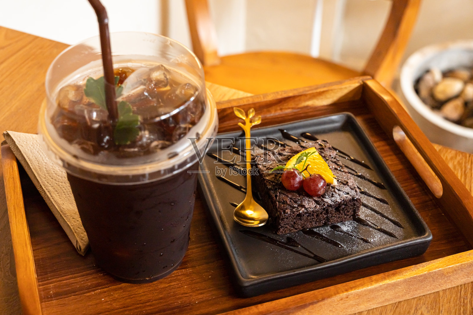 自制的新鲜烘焙的美味巧克力和巧克力橙布朗尼和美式冰咖啡或黑咖啡在木桌办公桌在咖啡厅咖啡厅在花园，在商务工作期间照片摄影图片