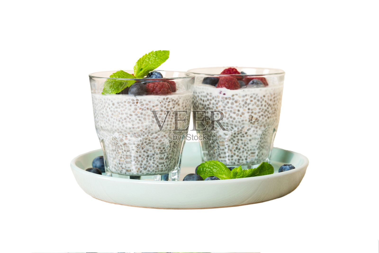 健康早餐或早餐以奇亚籽香草布丁覆盆子和蓝莓浆果为餐桌背景，素食，饮食和健康的概念。覆盆子蓝莓布丁照片摄影图片