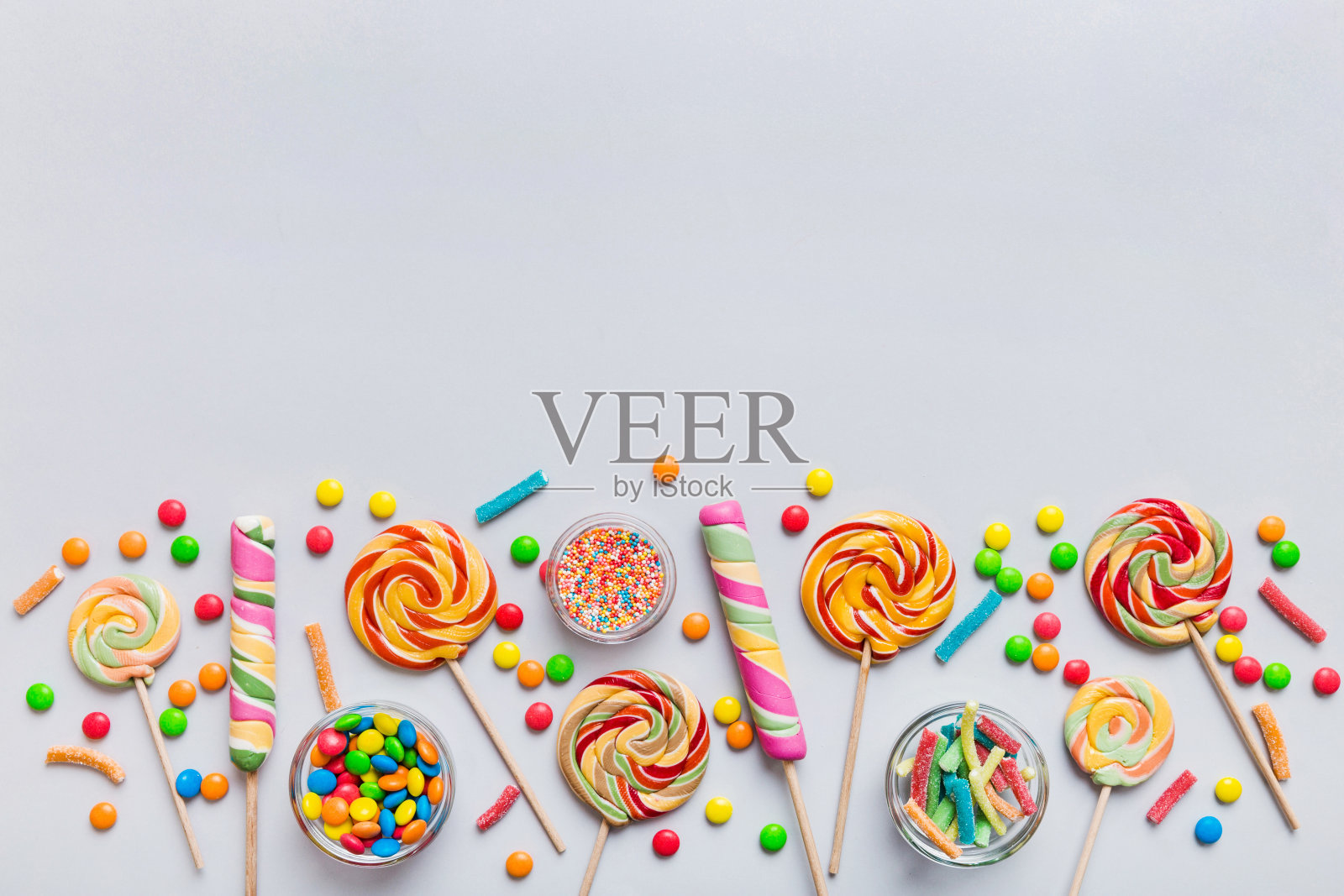 美味开胃的派对配件生日快乐甜蜜。不同类型的糖果在彩色背景上，复制空间。色彩缤纷的生日派对背景照片摄影图片