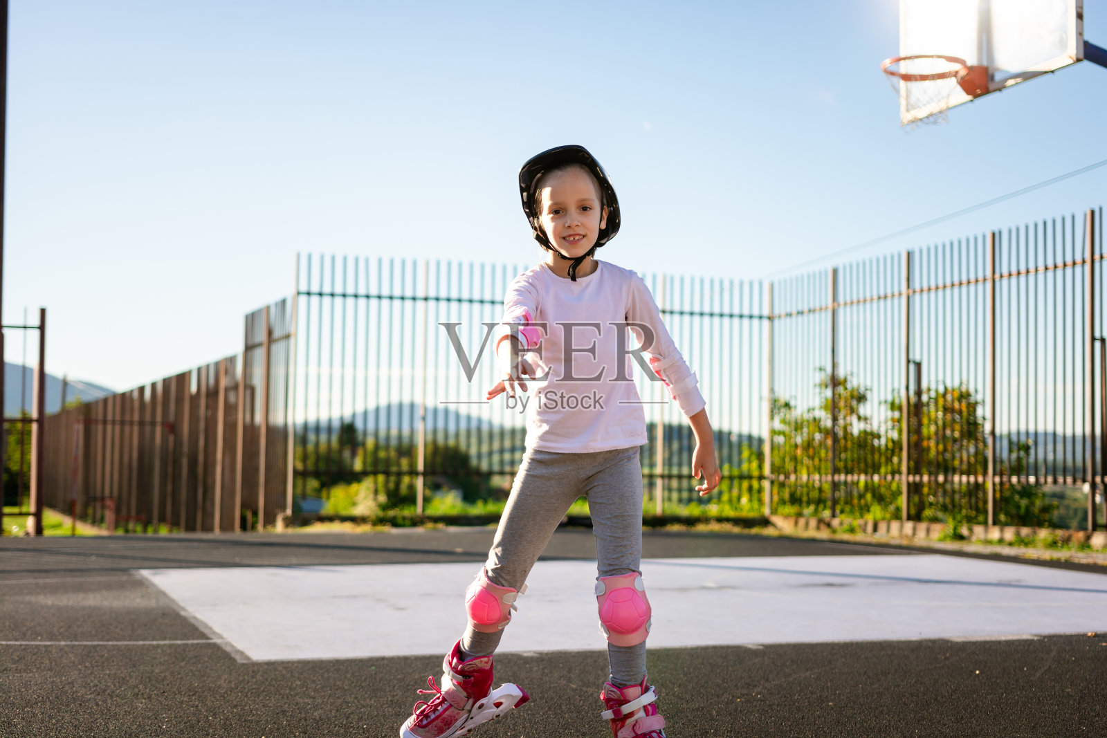 小女孩在户外练习轮滑。照片摄影图片