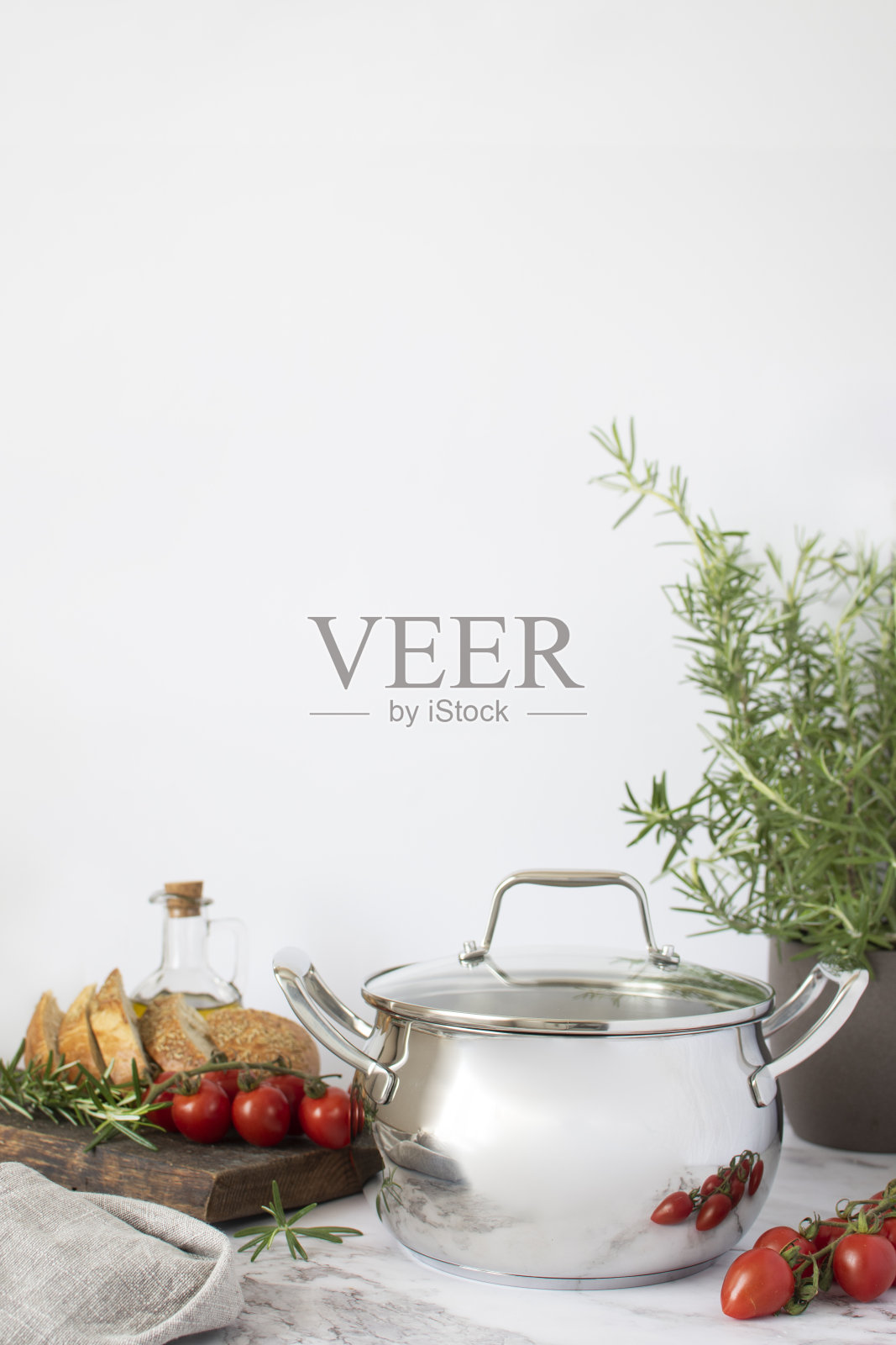 带盖子的不锈钢锅，里面有蔬菜和意大利面照片摄影图片