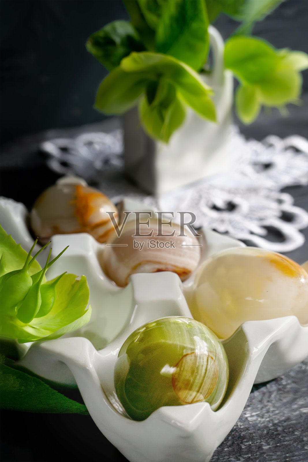 彩色的玛瑙球在有纹理的木板上。由天然玛瑙宝石制成的复活节彩蛋。时尚组织春假。特写，柔焦照片摄影图片