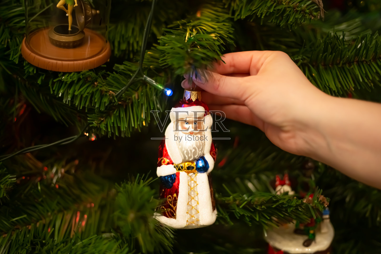 装饰圣诞树特写，留白区域。圣诞快乐，新年快乐。女人的手用球和玩具装饰圣诞树照片摄影图片