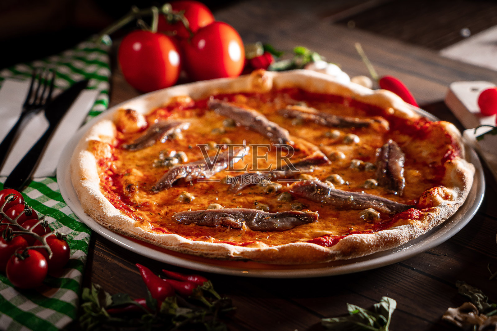 那不勒斯披萨配番茄凤尾鱼刺山柑靠近木桌照片摄影图片