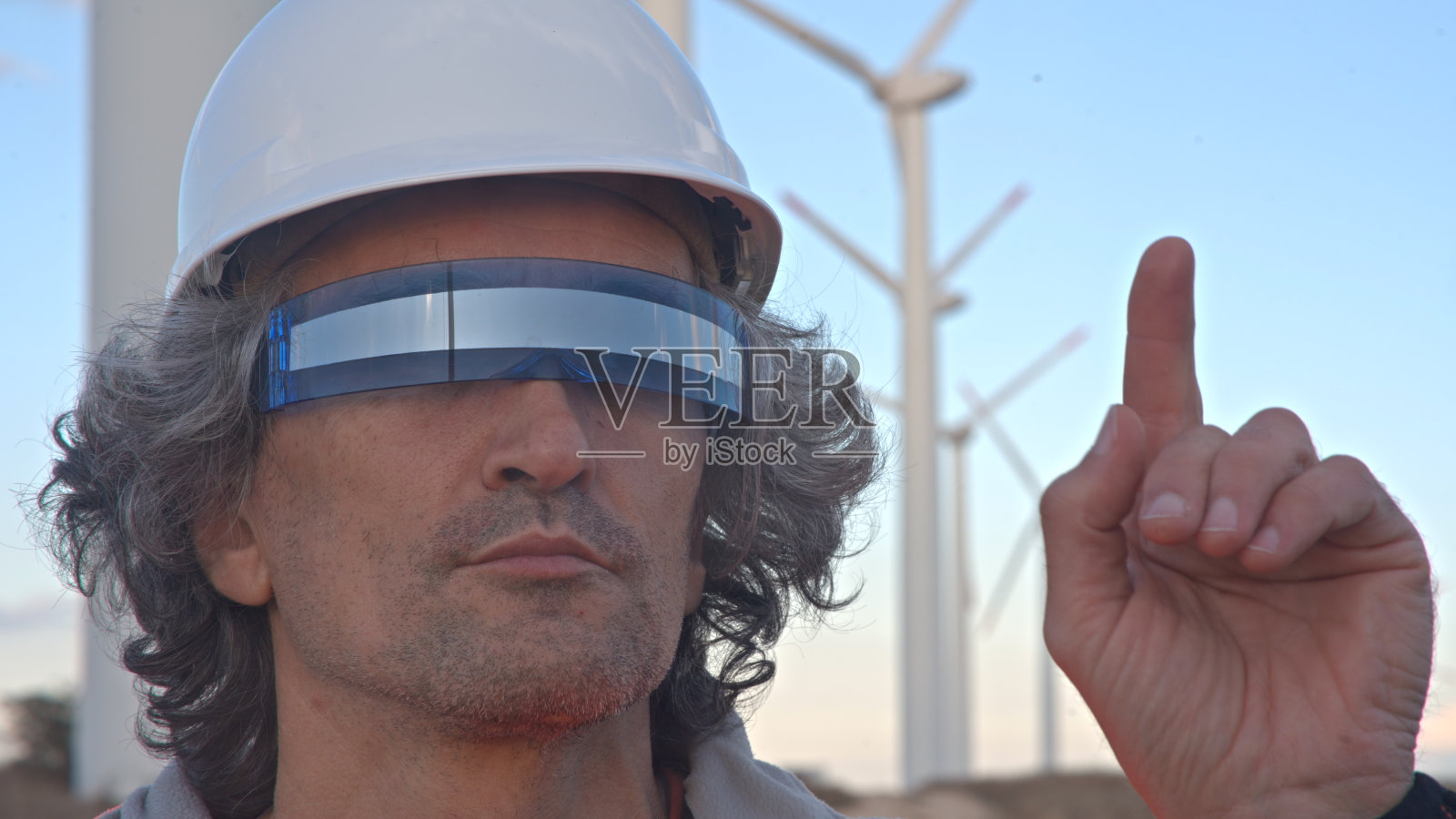 戴着VR眼镜的工程师在风电场工作。AR工具概念。照片摄影图片