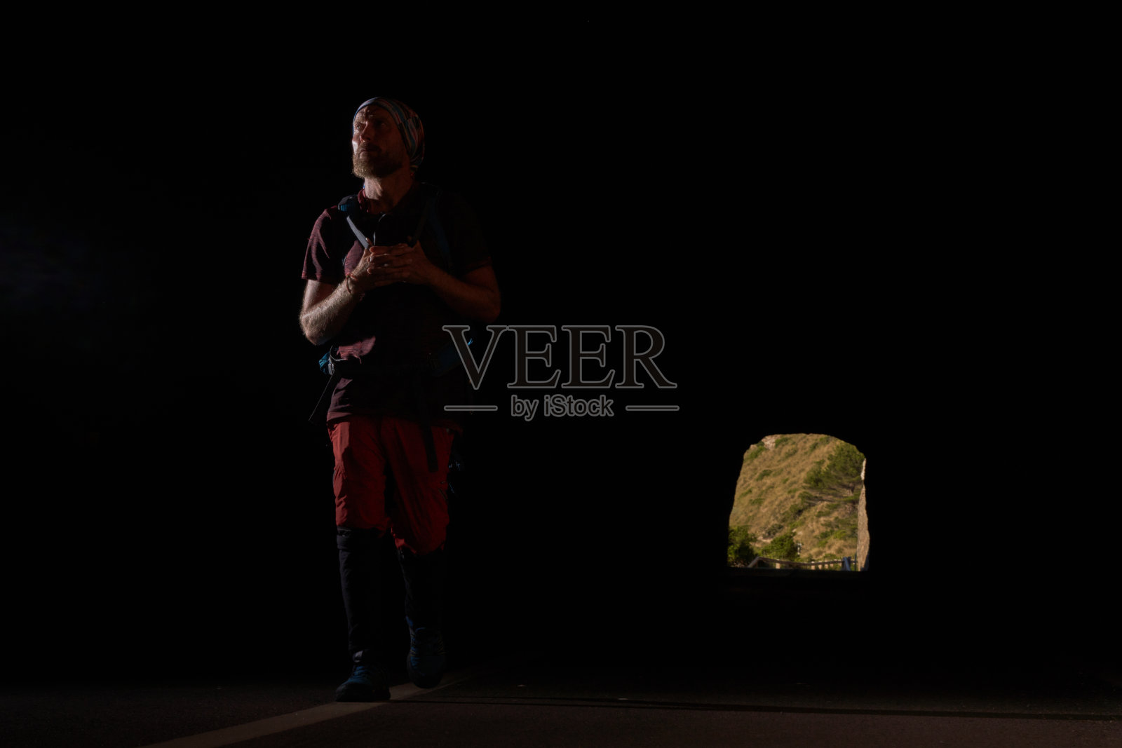 男旅行者走在黑暗的隧道里，向前看照片摄影图片