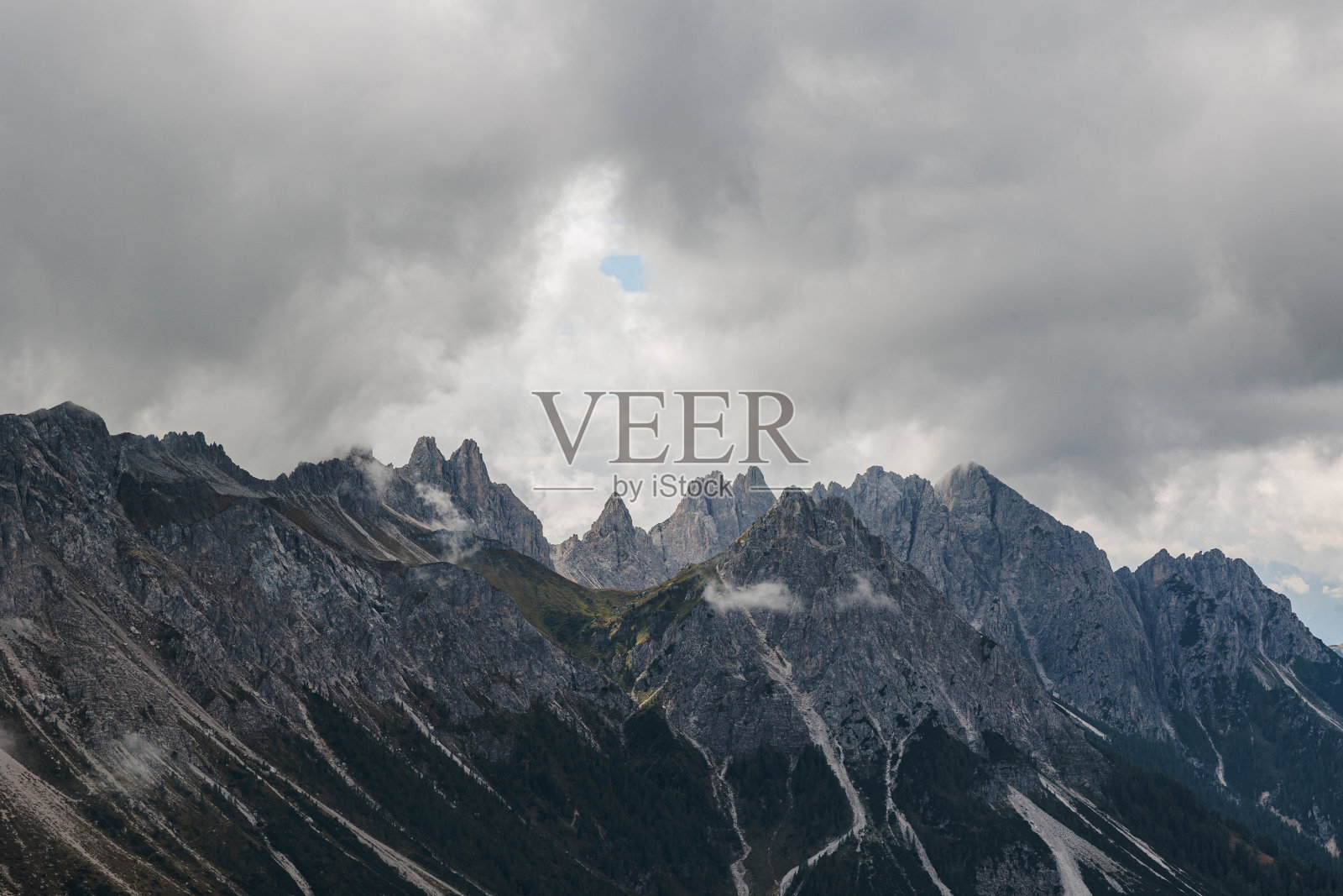 一个秋天的早晨，被暴风雨覆盖的岩石山脉的近景照片摄影图片