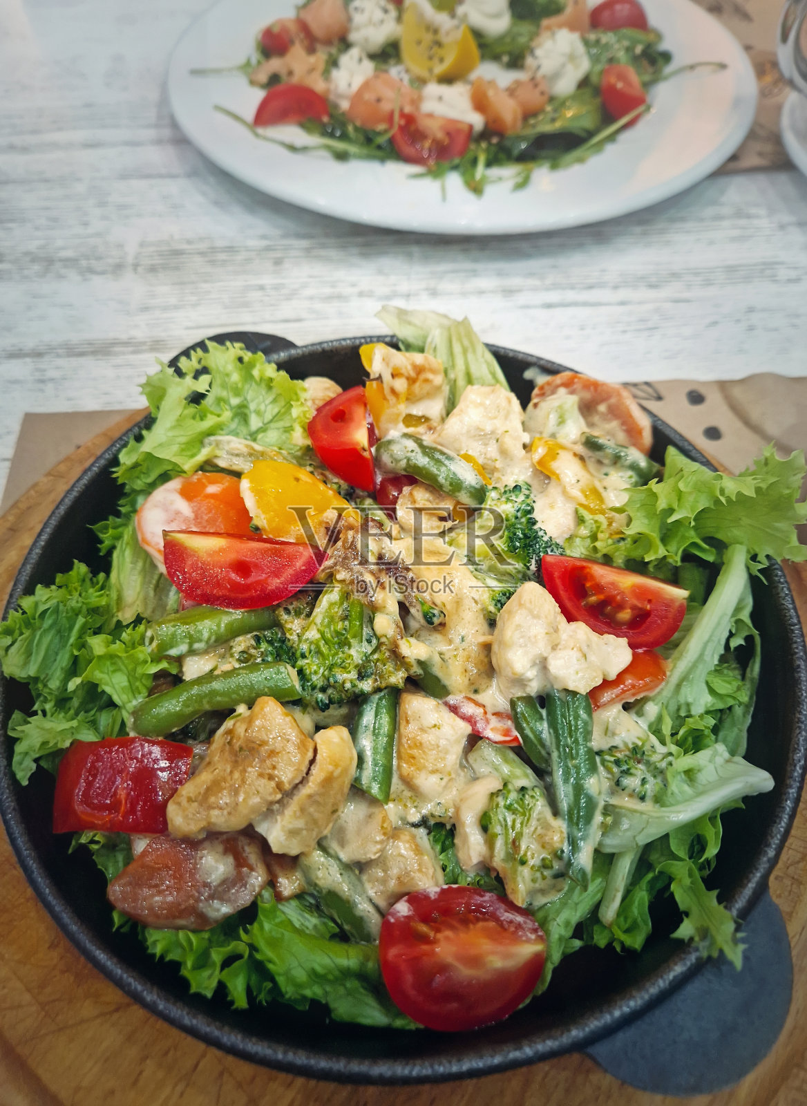 餐厅里的食物盘特写，前景是热沙拉照片摄影图片