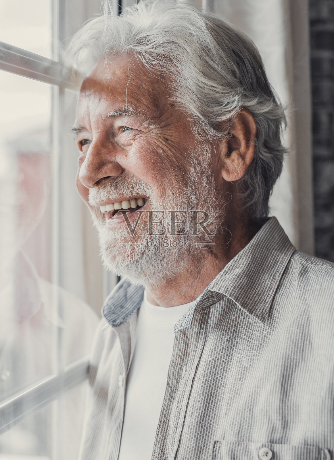 快乐体贴的70多岁老人满怀希望地望着窗外，想着身体健康、退休、保险福利，梦想着未来。领取退休金的长者等候与家人会面照片摄影图片