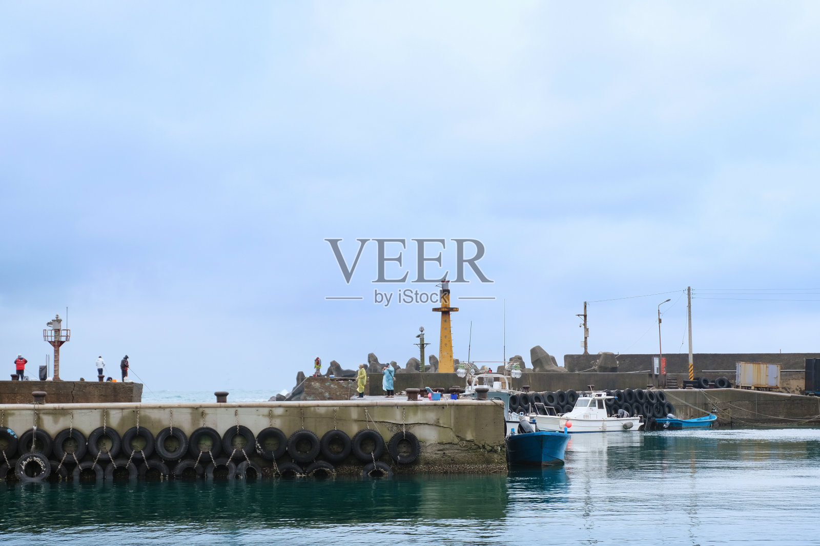 阴天的渔村里停满了抛锚的渔船照片摄影图片