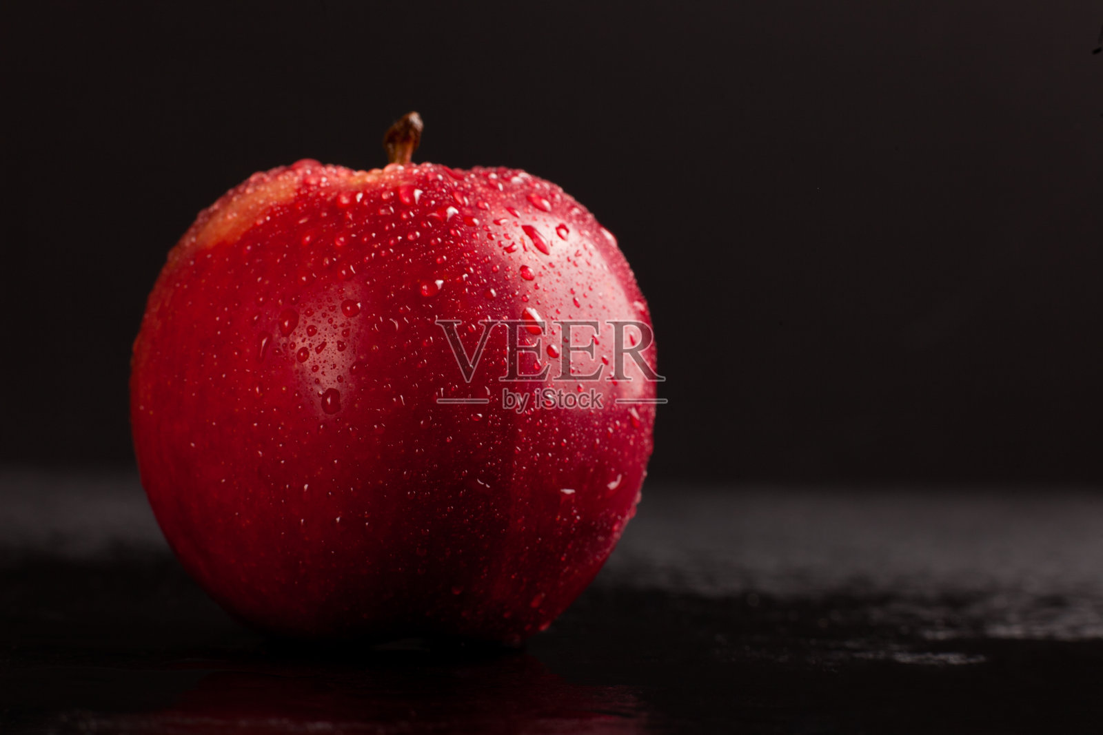 新鲜多汁的苹果在黑色背景的水滴照片摄影图片