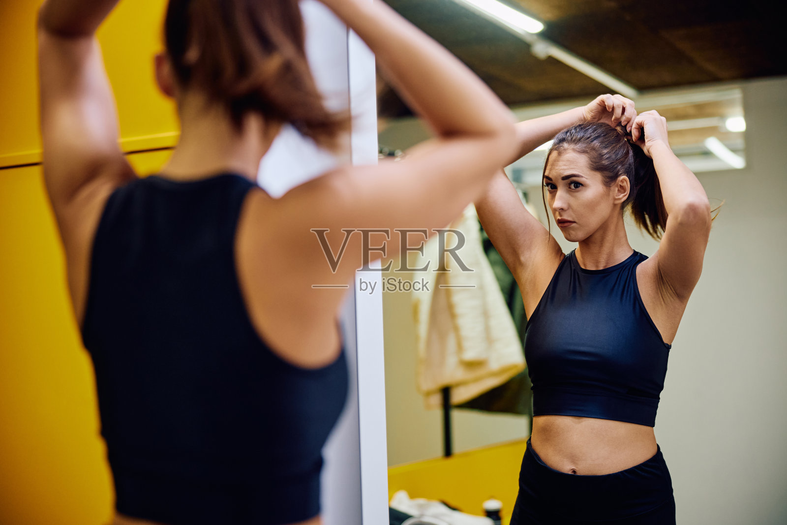 一名运动员在准备去健身房锻炼时扎着马尾辫。照片摄影图片