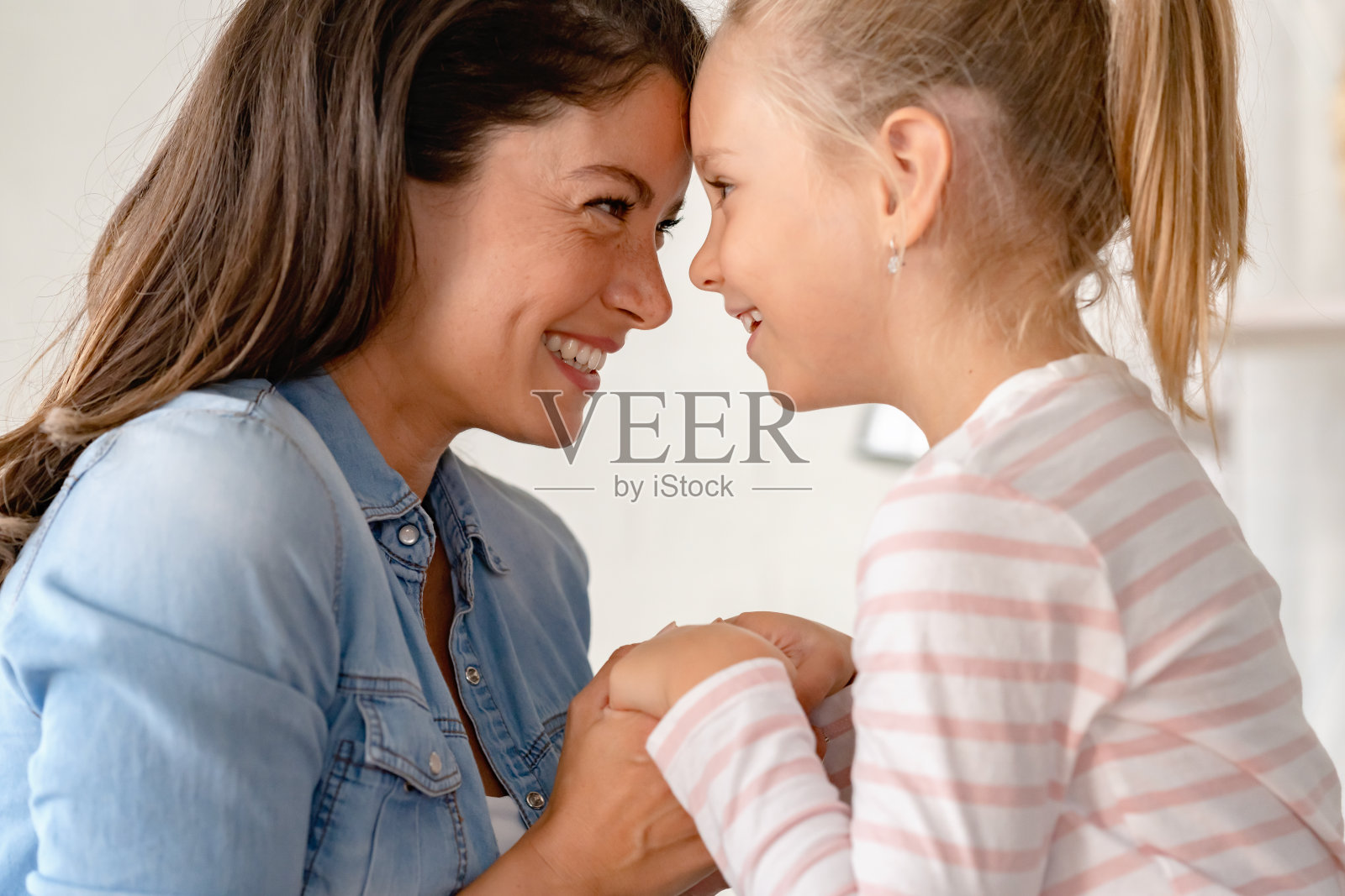 一位快乐的母亲和她可爱的小女儿在一起玩，一起欢笑照片摄影图片