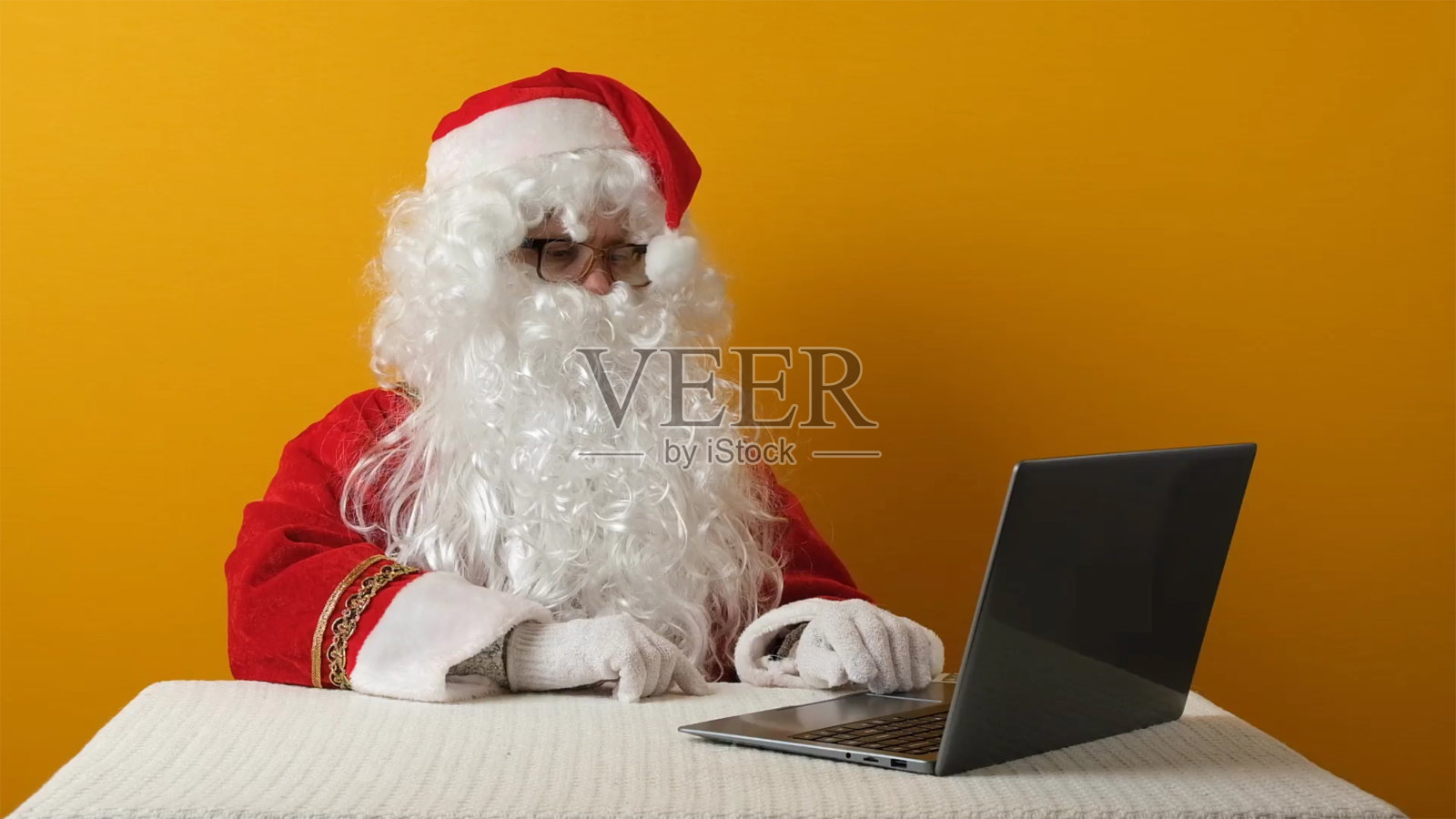 圣诞老人送钱美元和笔记本电脑。照片摄影图片