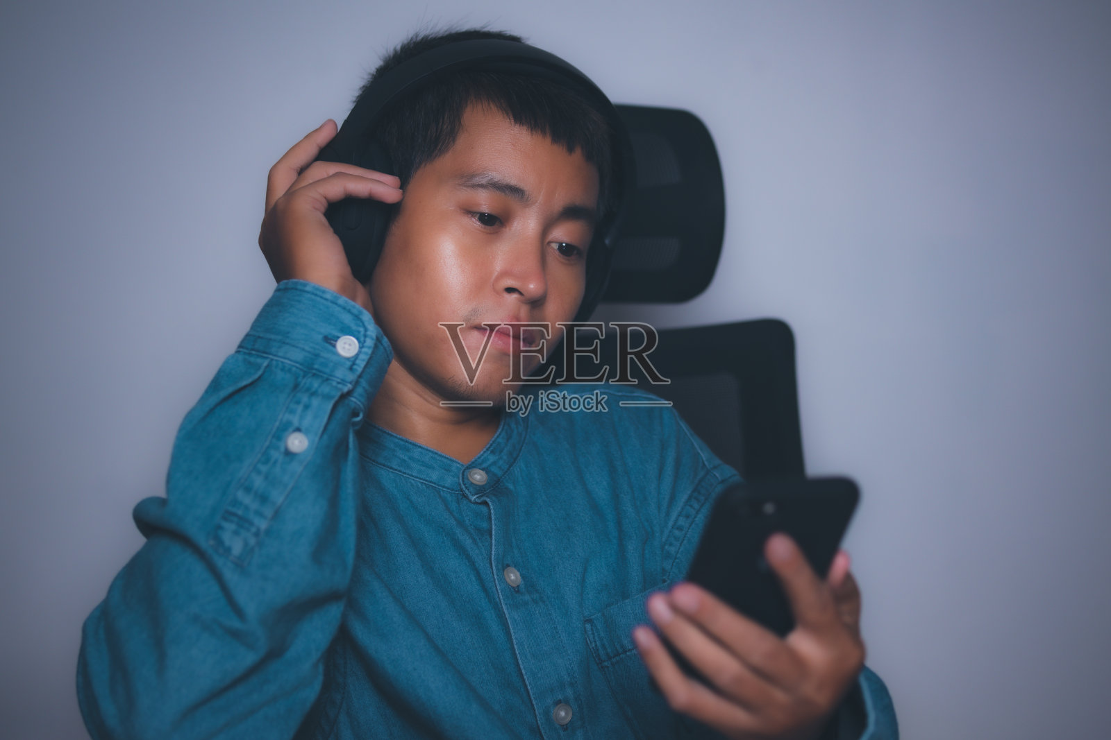 男人用耳机享受听音乐。照片摄影图片