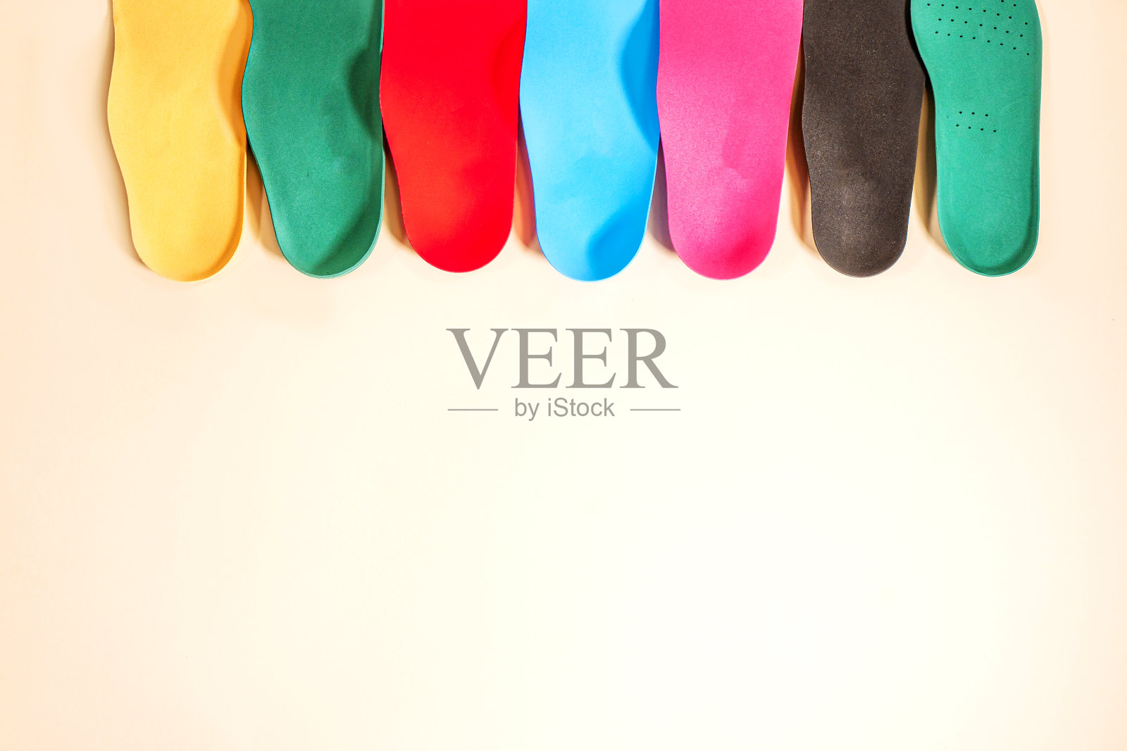 彩色背景鞋用矫形鞋垫。足部护理照片摄影图片