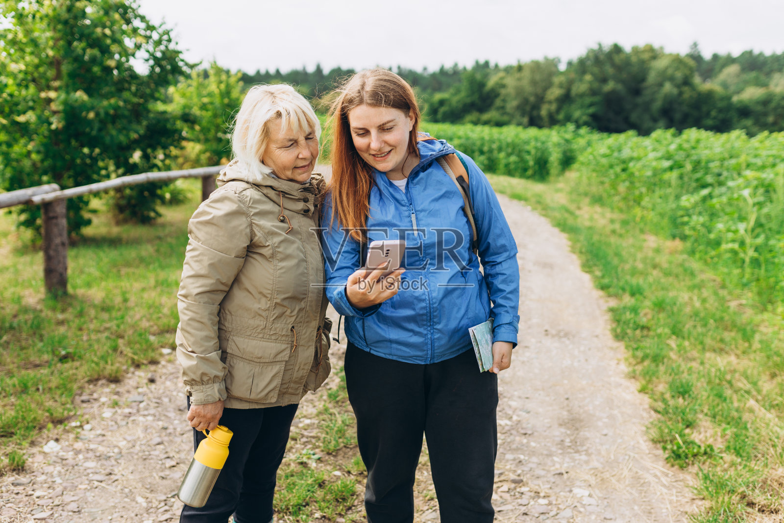快乐的两个探险家使用手机在户外导航。旅行和积极的生活方式理念。自驾游，交通，旅游，科技和人的旗帜照片摄影图片