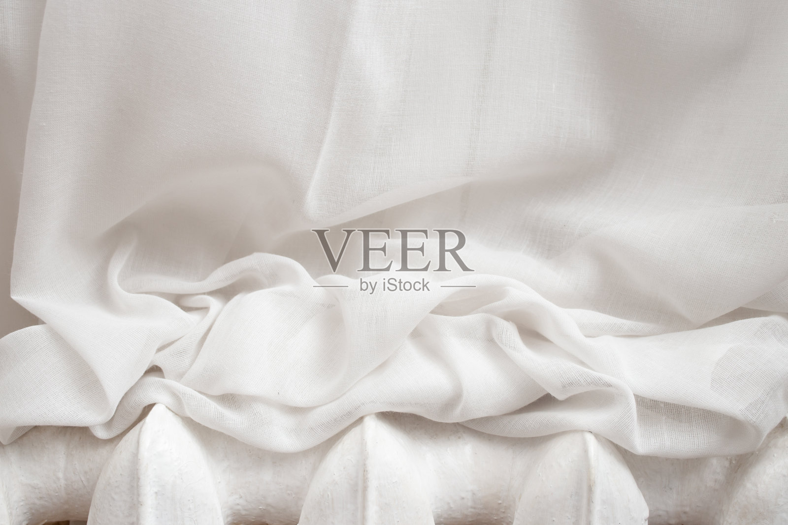 白色的窗帘放在金属加热器上，抽象的纹理背景照片摄影图片