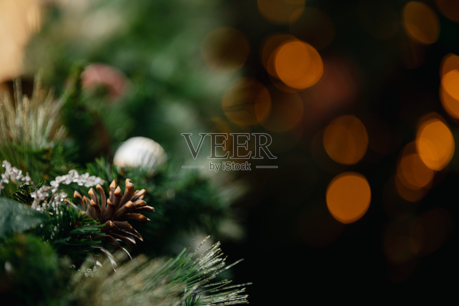 圣诞背景——绿色的圣诞树树枝，红色和金色的装饰品，彩灯。照片摄影图片