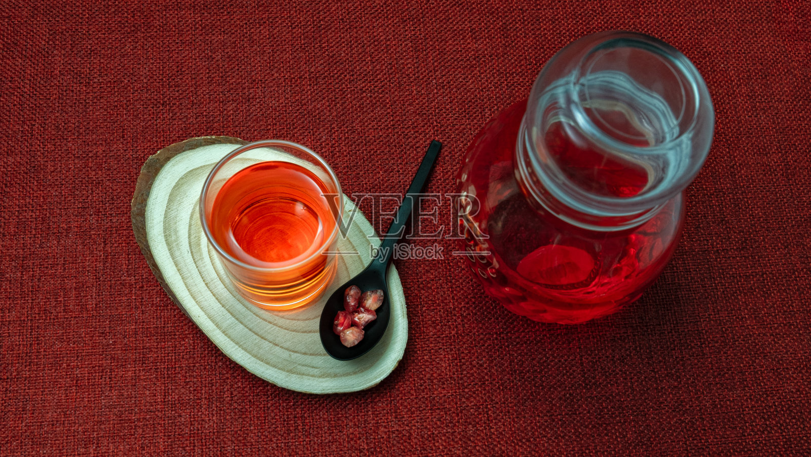 一杯石榴汁，旁边是新鲜多汁的石榴照片摄影图片