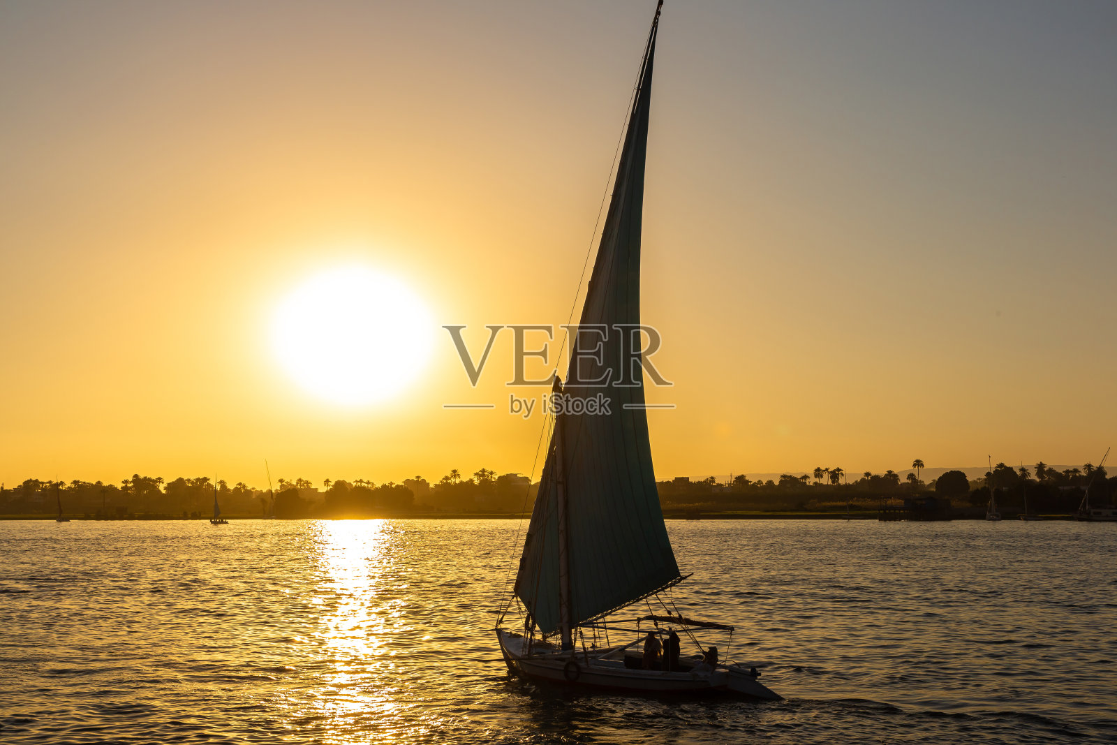 尼罗河日落时分的帆船照片摄影图片