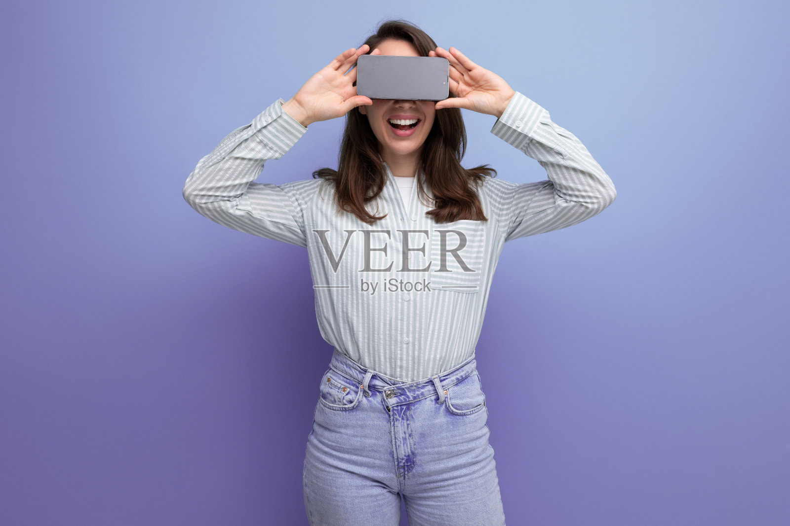 衣着整洁的25岁棕发女子在电话里播放广告照片摄影图片