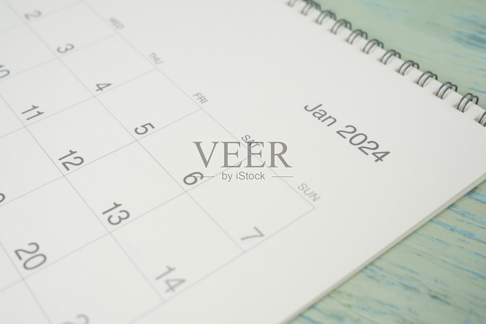 关闭2024年1月日历上的蓝色表背景，规划商务会议或旅行规划的概念照片摄影图片