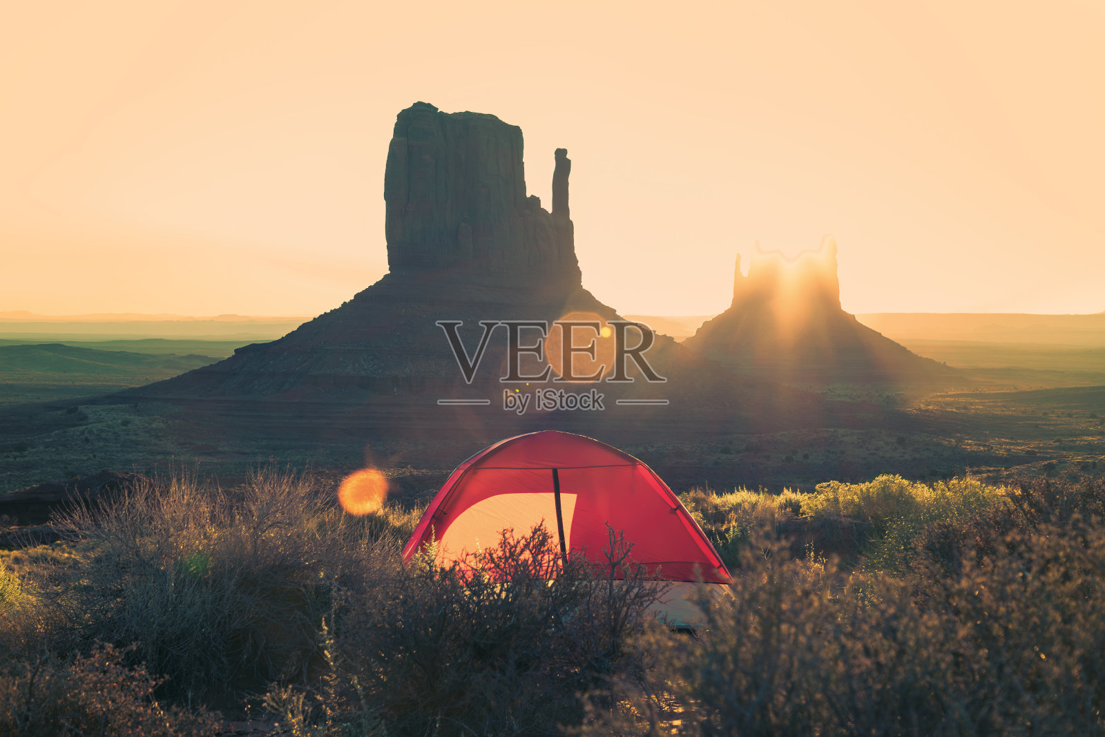 在纪念碑谷露营，清晨在孤峰后欣赏日出照片摄影图片