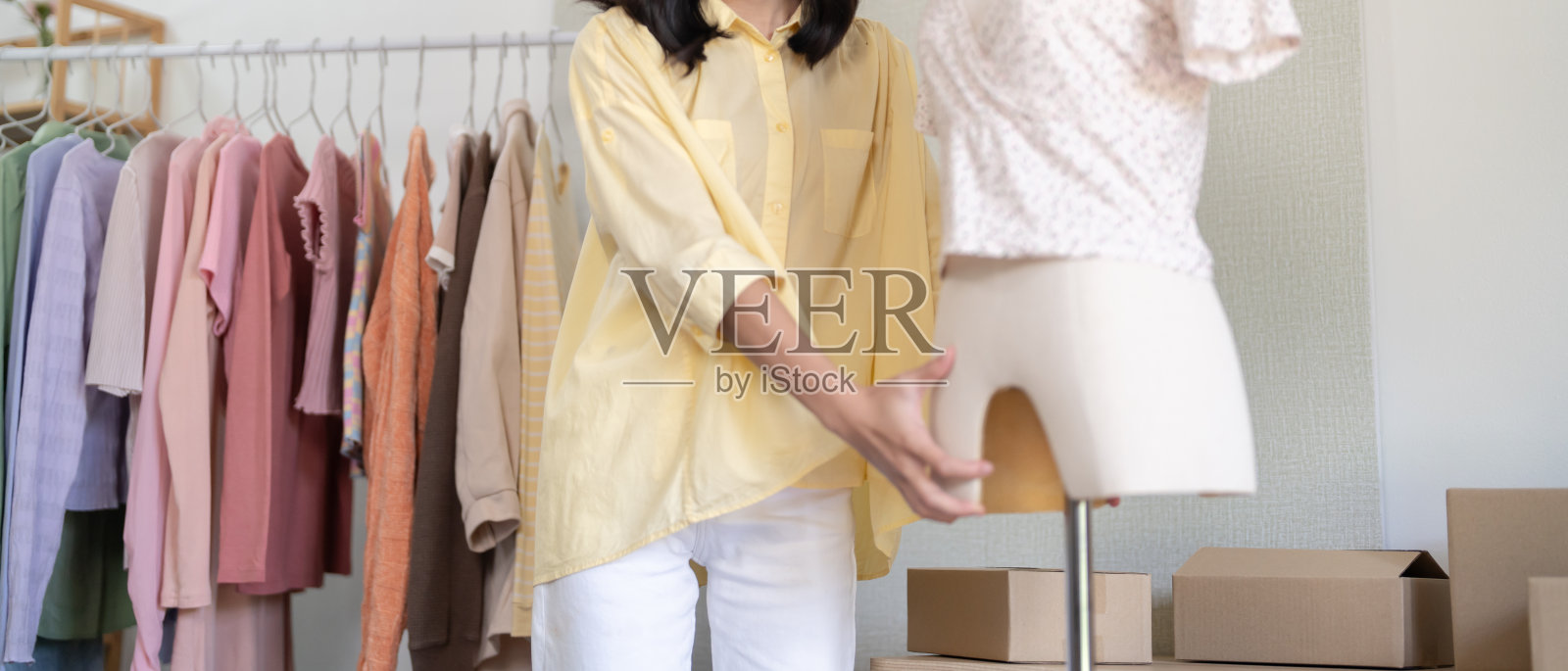 亚洲女裁缝工作在时装工作室设计和运送一个在线订单的女人发送packageÂ在线咨询服装店照片摄影图片