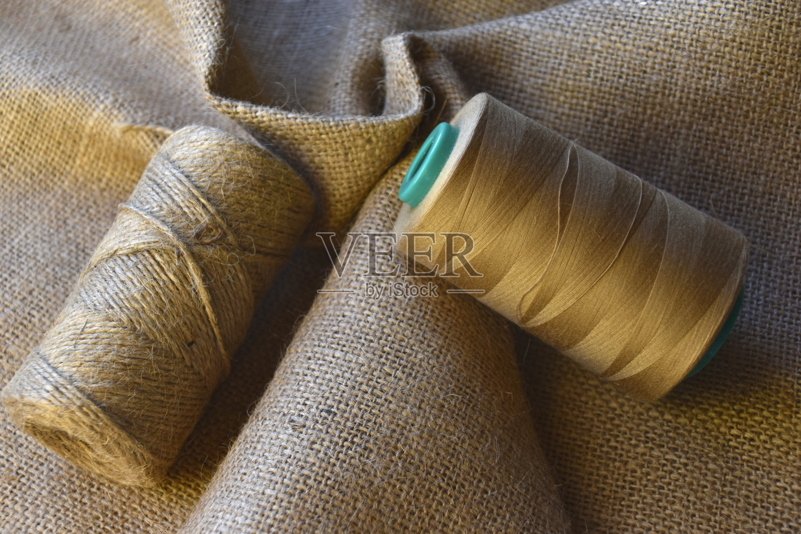 皱巴巴的粗麻布上的一串串线。粗布上的黄线。做袋子的材料。照片摄影图片