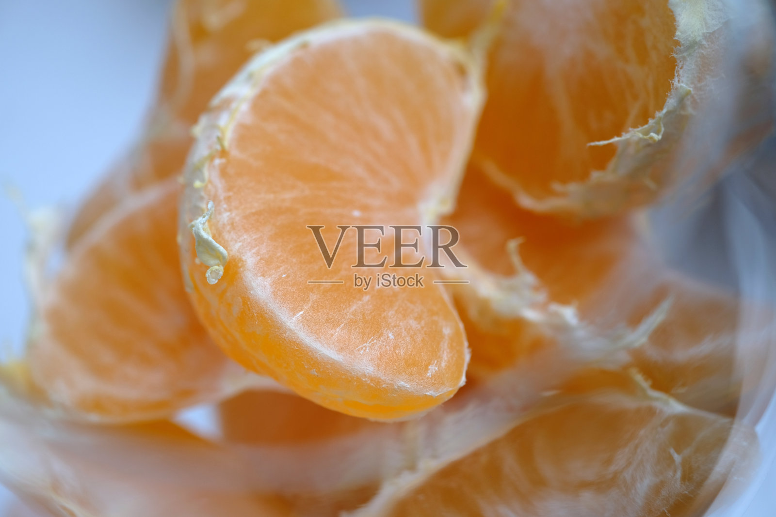 将去皮的橘子片放入玻璃杯中照片摄影图片