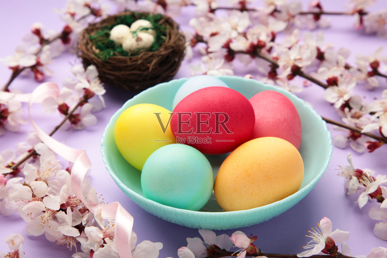 复活节快乐。五颜六色的复活节巧克力彩蛋，紫色的背景上有樱花。贺卡或横幅照片摄影图片