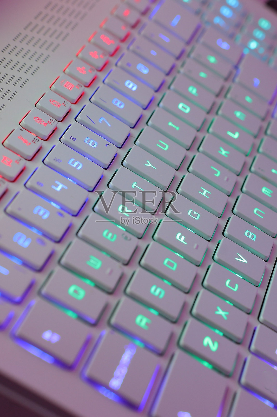 在彩色背光的霓虹灯电脑键盘上工作。电脑游戏，黑客，科技，互联网概念。选择的重点。照片摄影图片