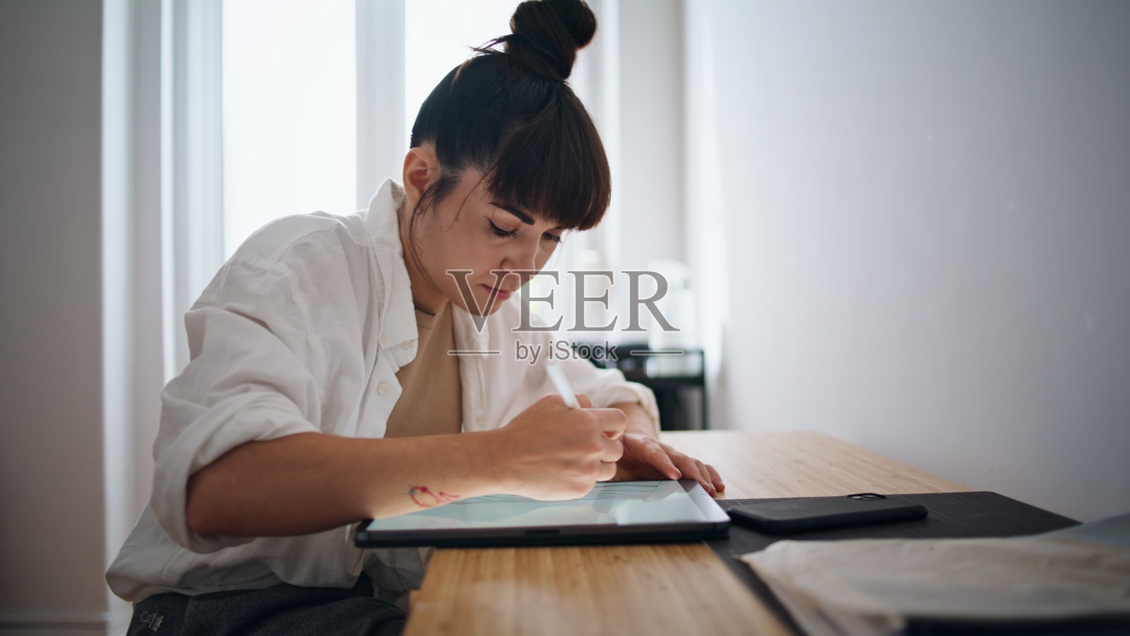 纹身艺术家在舒适的地方画素描特写。女子使用平板电脑照片摄影图片