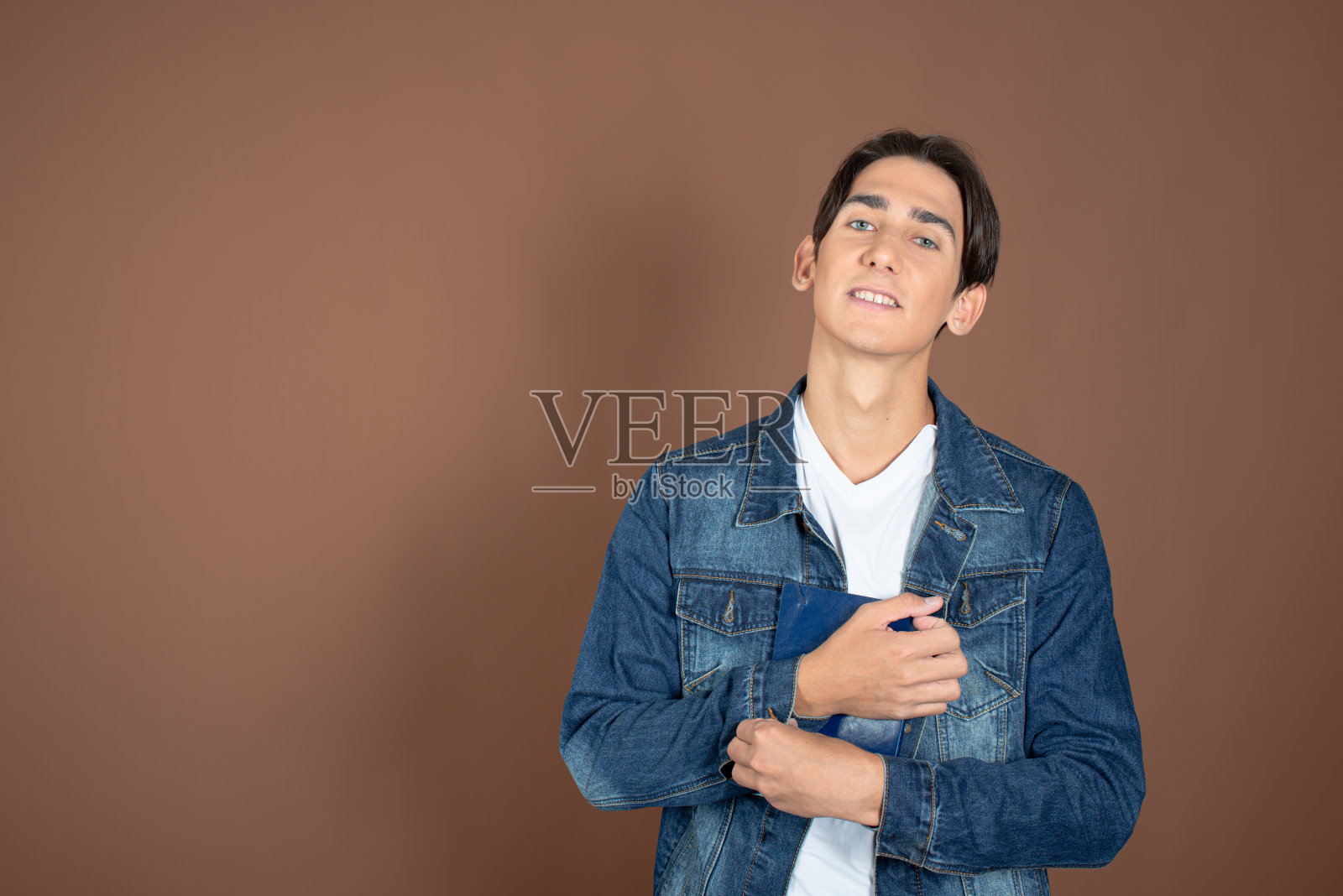 年轻人和学习。有趣的帅哥在棕色背景上摆姿势。照片摄影图片