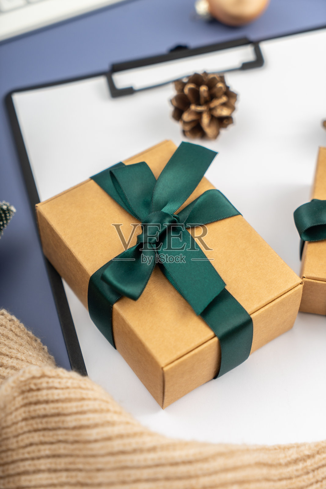 圣诞节的概念。圣诞礼物在剪贴板上的淡蓝色背景。照片摄影图片