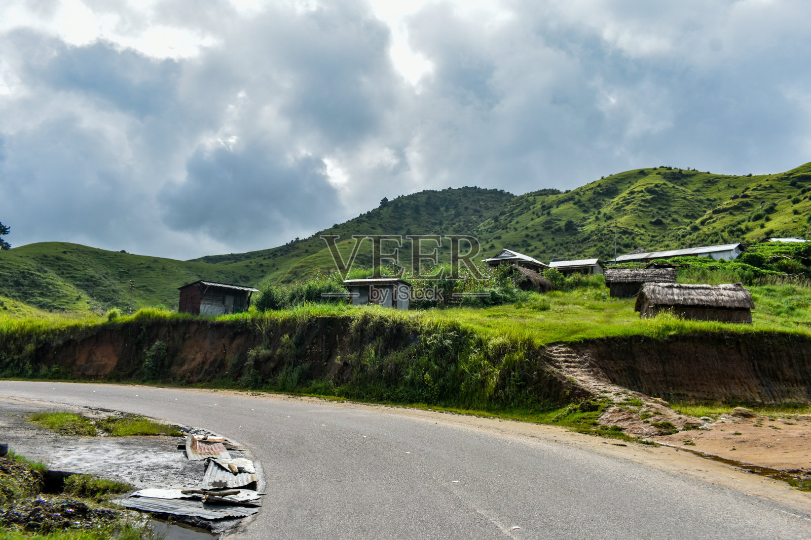 一条穿过山丘、村庄和丛林的道路。照片摄影图片