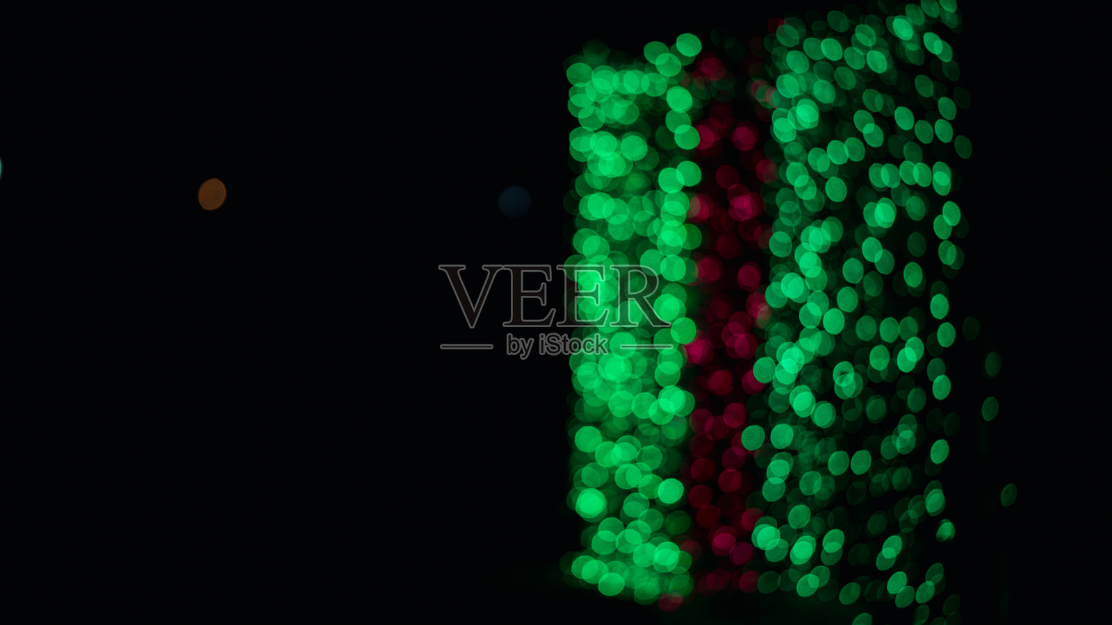 暗色背景下的淡绿色散景。照片摄影图片